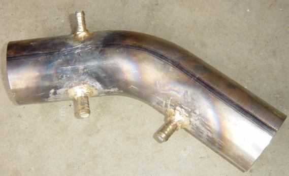 Air intake under construction. An off the shelf 75mm exhaust bend from the local truck spares.
<br />The 75mm rubber joiner to the throttle body is a stock truck spare as well.