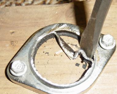 Chisel out the remaining bit. Not as hard as it looks as the flanges are brazed to the pipe and comes away quite easily. The bronze is also easy to grind out to take the larger pipe.