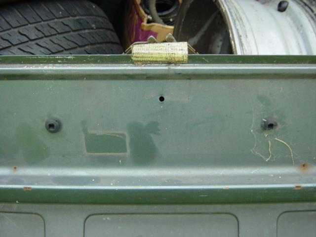 Behind number plate.